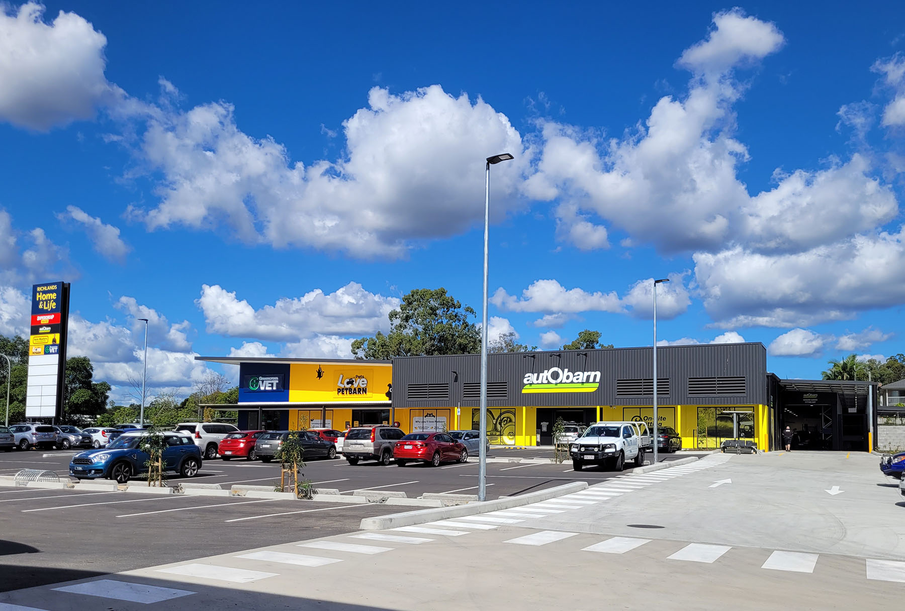 Industrial Buildings, Warehouse, retail buildings, Exterior Image of Petbarn, Autobarn & Vet, Grey, Yellow and Blue colours throughout.