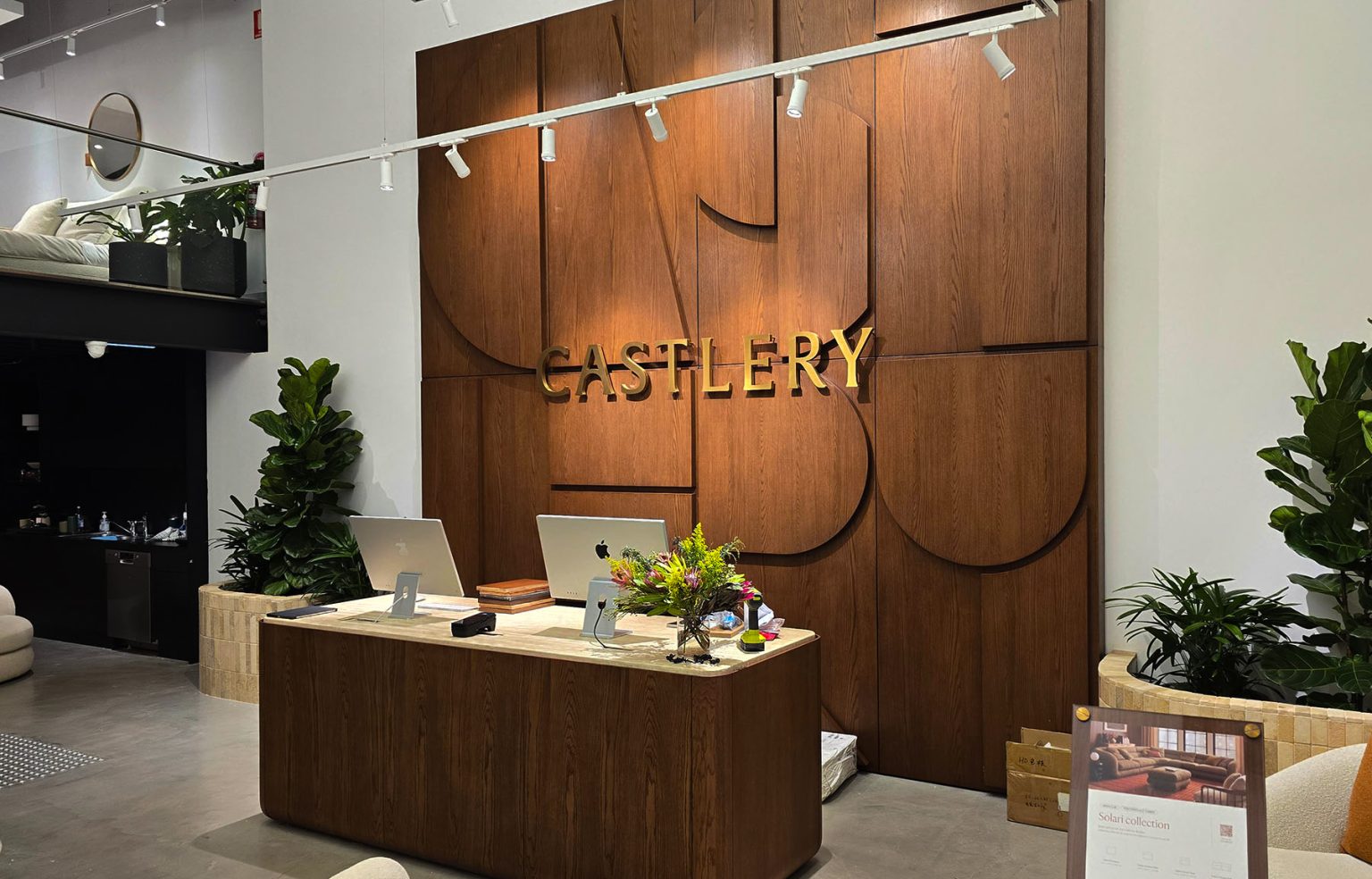 Castlery showroom front desk, displaying the feature wall made of wood with a rounded pattern.