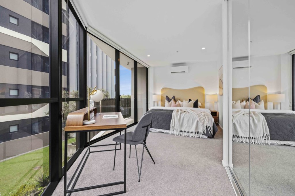 Interior Image of Hillyard House apartment displaying carpeted floors, glazing along the side of the room with the view of suburbia Brisbane.