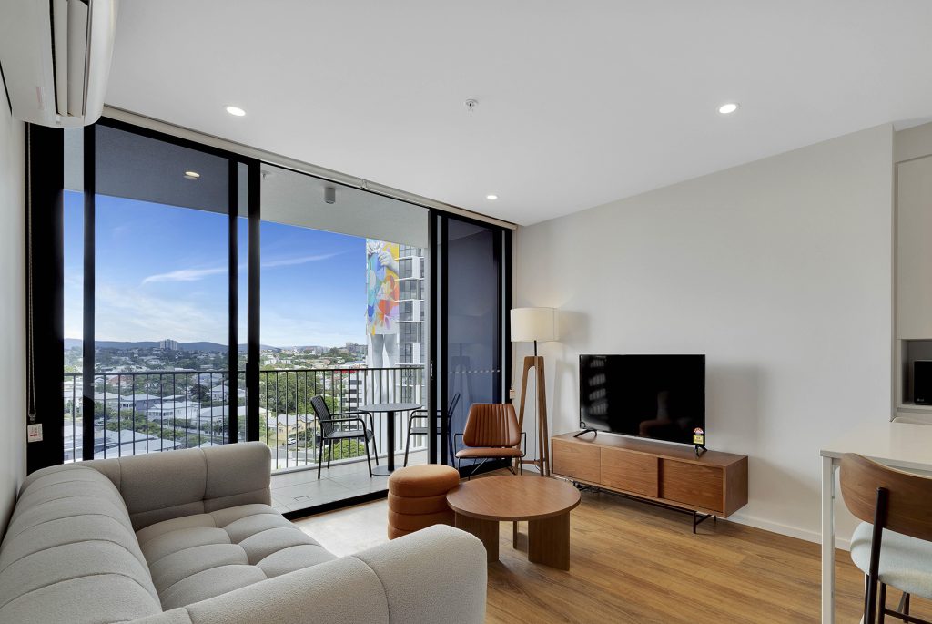 Interior Image of Hillyard House apartment displaying wooden floors, balcony with the view of suburbia Brisbane.