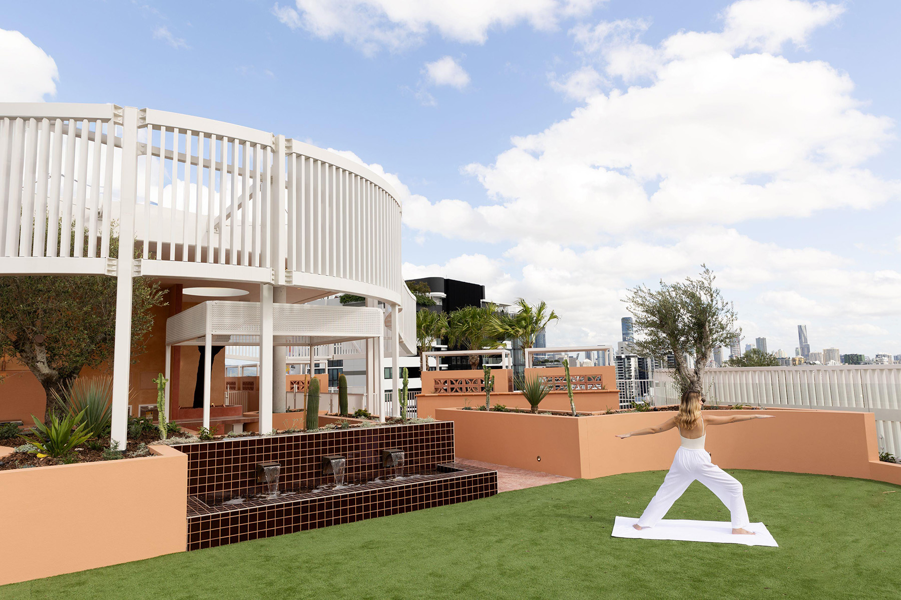 Roof of story house, displaying the grassed area, curved metal feature and terracotta tiles.