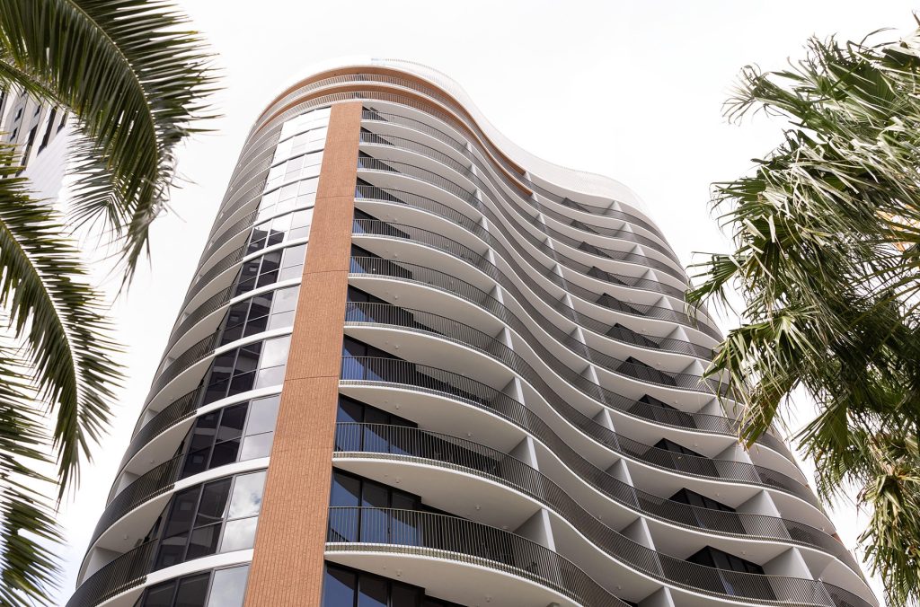 This image displays the curved facade of the building, displaying white, black and terracotta colours.